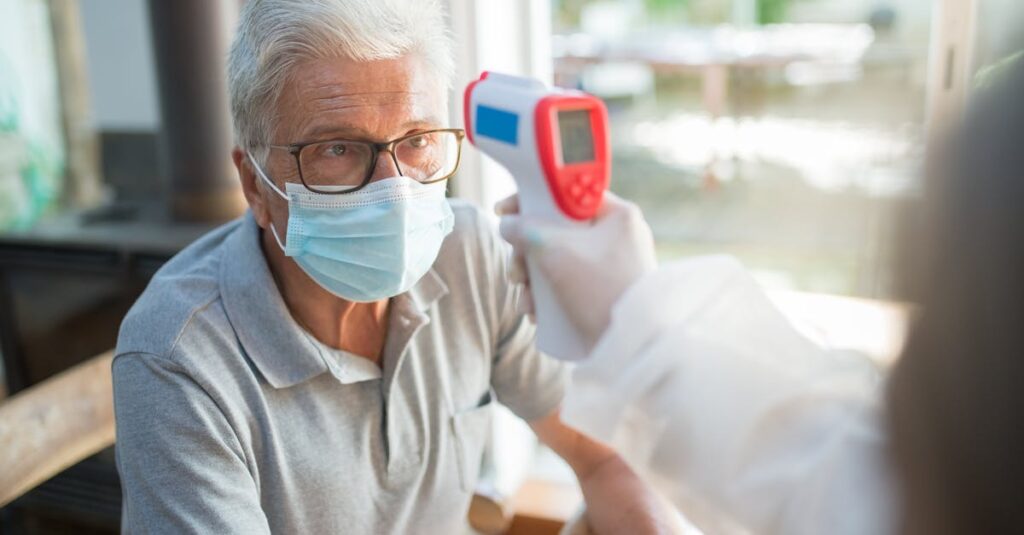 獣医に老猫を抱えて相談している飼い主と猫の穏やかな診察風景